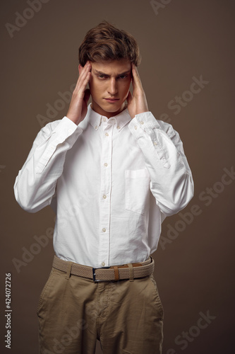 business man in shirt holding his head official beige background
