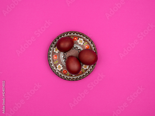 Easter eggs on a plate. Pink background. Spring holiday treat.