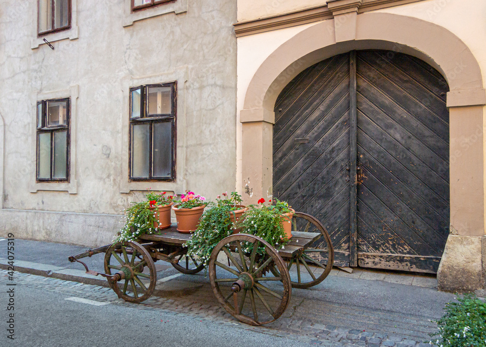 Wooden cart with flower pots on in front of an historic building in the city of Zagreb, Croatia