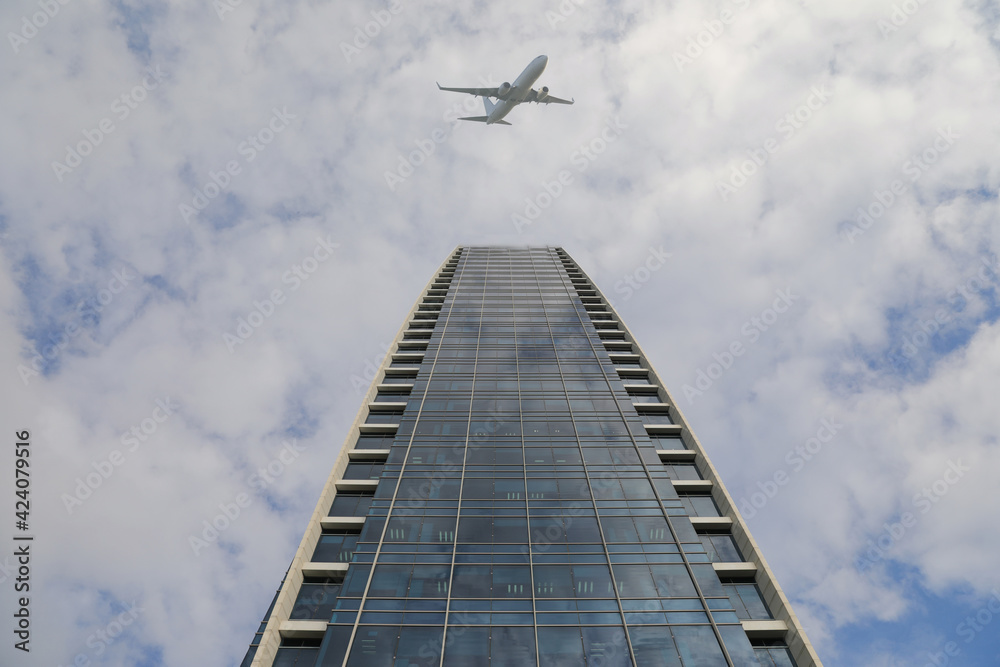 Modern abstract tall city buildings and a plane flying overhead in the sky. Modern abstract tall city buildings and a plane flying overhead in the sky.