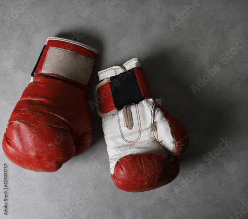 Boxing gloves on the gym floor after training. Gray grunge concrete background