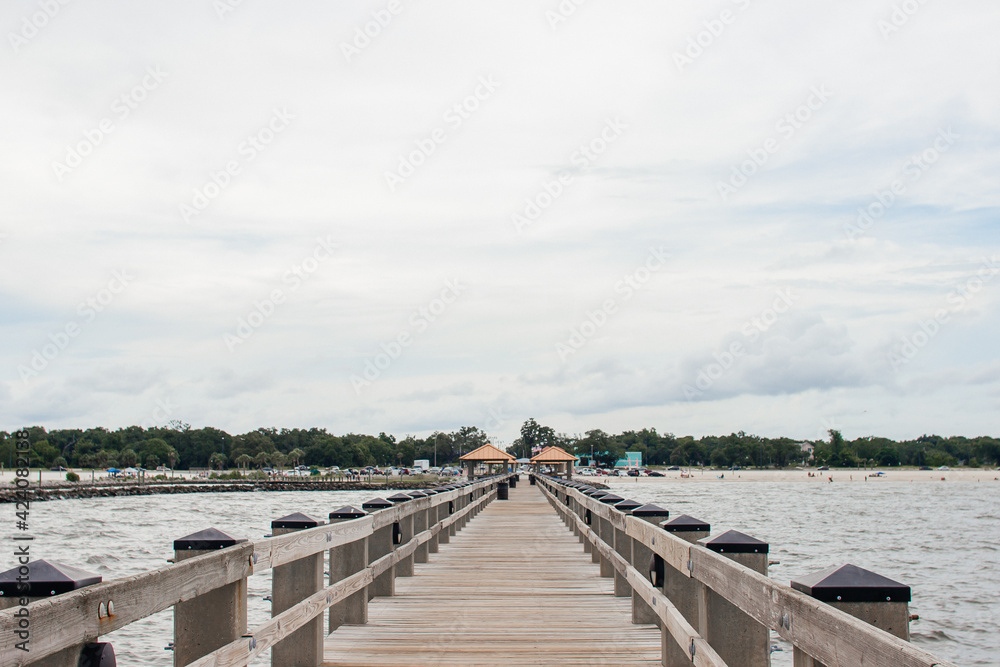 Obraz premium Seascape. Wooden pier with gazebos with orange roofs. Summer background. Ken Combs Pier, Gulfport, MS, USA
