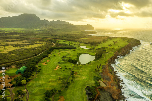 A blustery day in paradise, Rugged mountain ridges and coast line under heavy clouds, rain and sun over the ocean, Maha'ulepu Heritage Trail, Makawehi Bluff, Kauai..