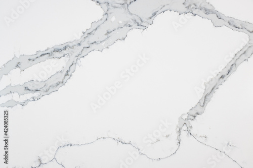 Close up of a quartz slab that contains both bold grey veins and subtle thin veins