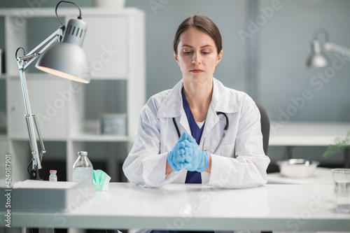 Portrait of a medical specialist in the workplace. A female doctor in medical gloves in the office of a private clinic.