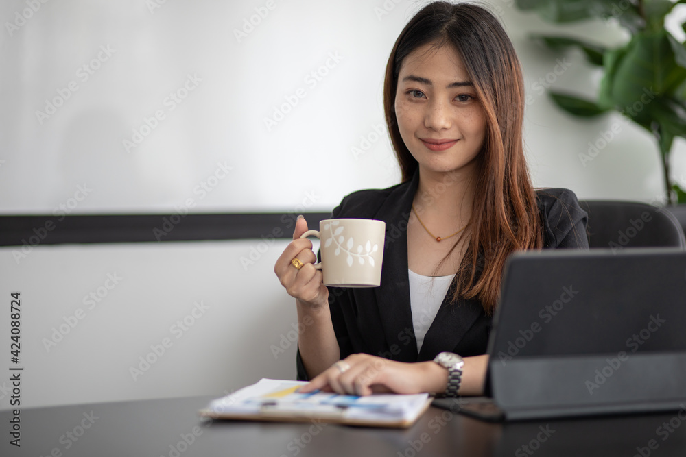 Portrait of Asian young female working on tablet at office