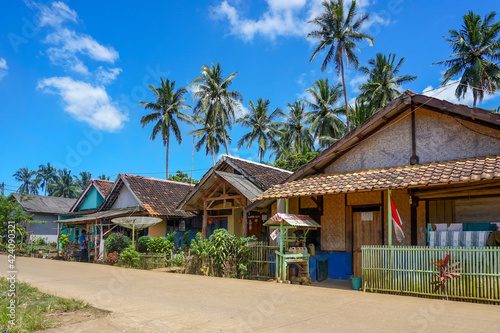 Traditional house of beachside village with coconut trees under blue skies. Daylight in the Countryside of Asia. 