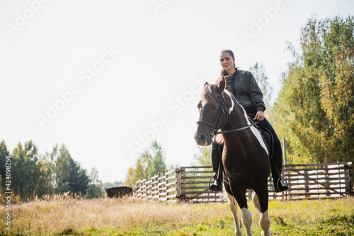 On a sunny day, the girl takes a ride on horseback through the expanses of her estate © Anna Kosolapova