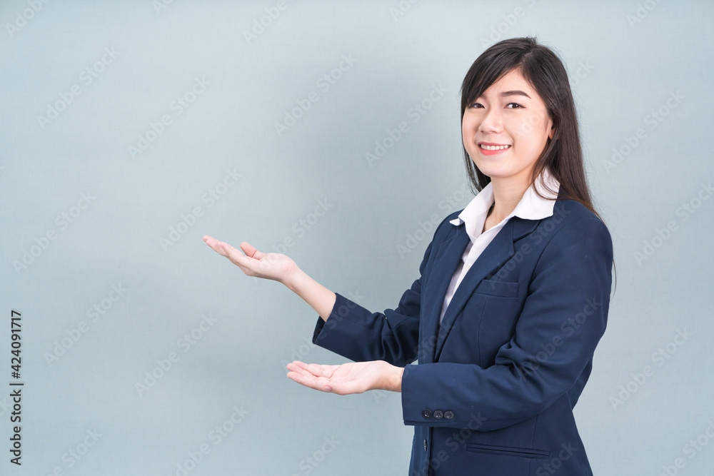 Asian woman in suit open hand palm gestures with empty space Asian woman in suit open hand palm gestures with empty space