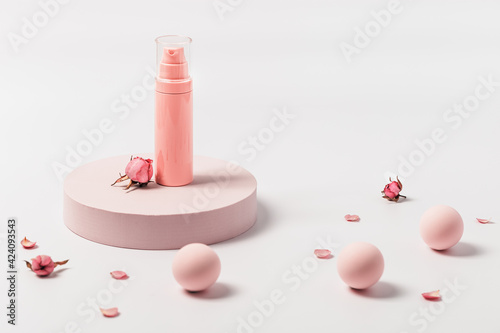 Aroma beauty cream container with essential oil flower of rose on round podium. Cosmetic product, pink pastel colored