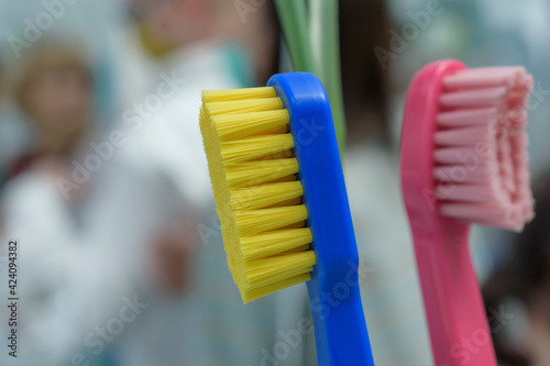 Close-up toothbrush. Blue plastic, yellow brush bristles. Abstract background.