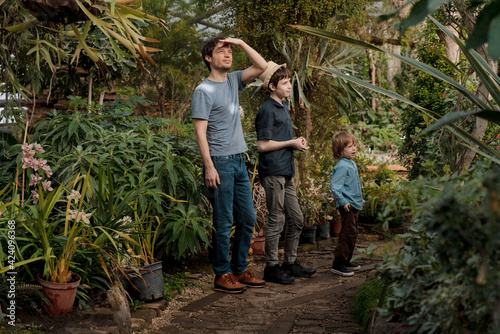 Adventurous family inspecting tropical gallery in Botanical garden. Local travel