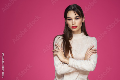Woman with red lips bright makeup white blouse long hair pink background