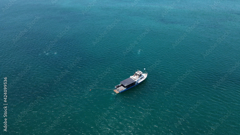 Fishing boat in turquoise water sea aerial shot