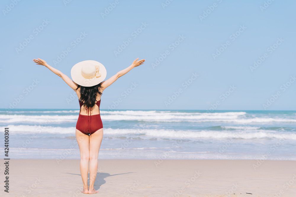 Beautiful young asian woman in swimwear relaxing at the beach during summer vacation Beautiful young asian woman in swimwear relaxing at the beach during summer vacation