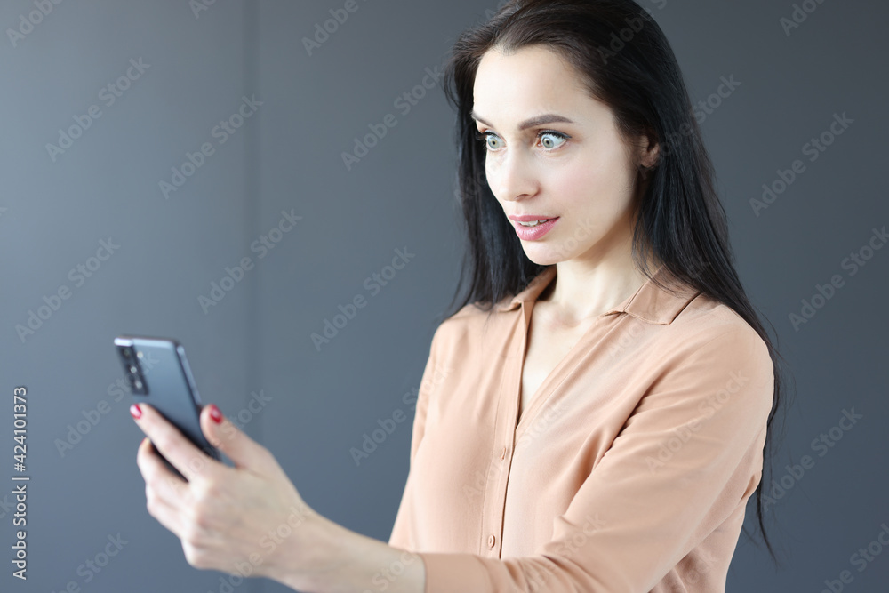 Surprised woman looking at mobile phone screen Surprised woman looking at mobile phone screen