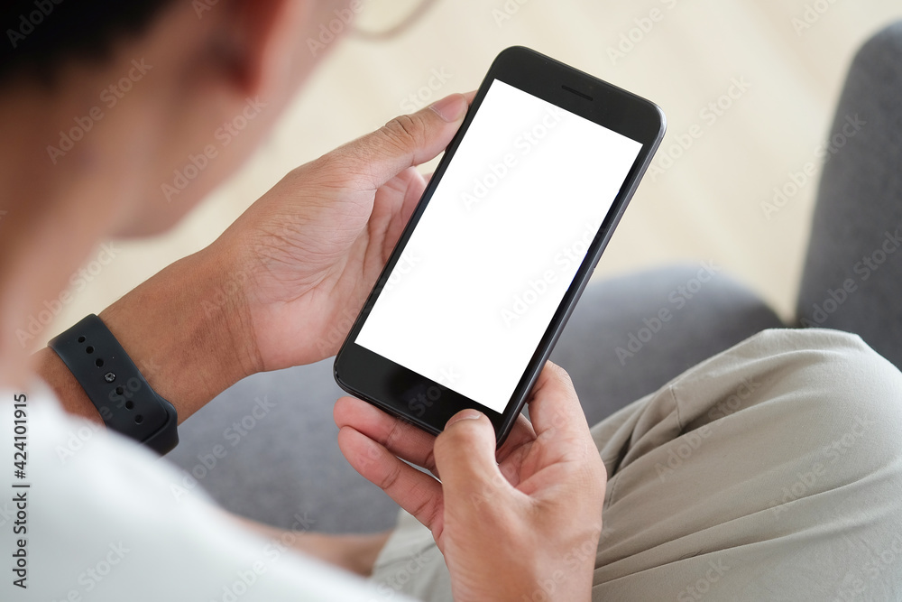 Close up view of man sitting on sofa and using mobile phone. Blank screen for advertise text.
