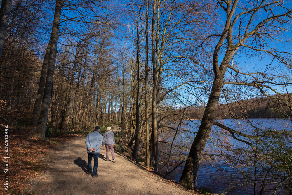 Älteres Paar macht einen Waldspaziergang am See im Frühling.