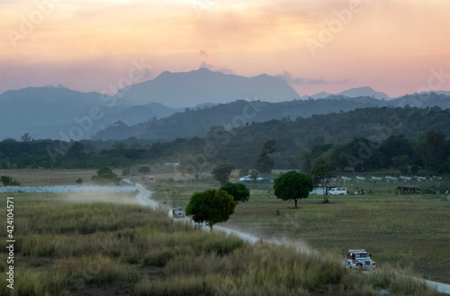 Picturesque Evening in the Tropics: Dirt Road, Expansive Fields, and Jagged Mountains outside Clark, Pampanga, Philippines photo