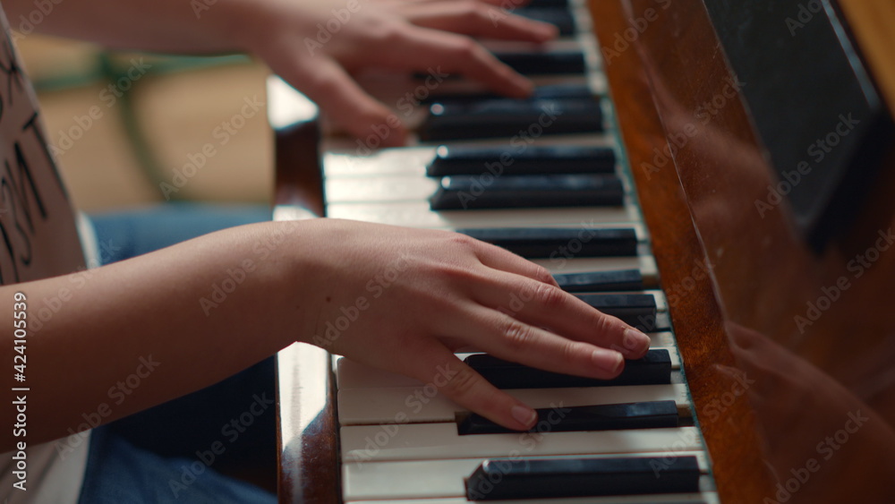 Obraz premium Close up of unidentified hands playing piano indoors. Pianist hands practicing.