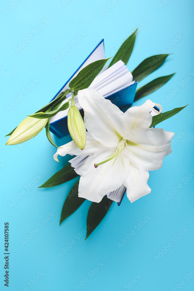 Books with beautiful lily flowers on color background