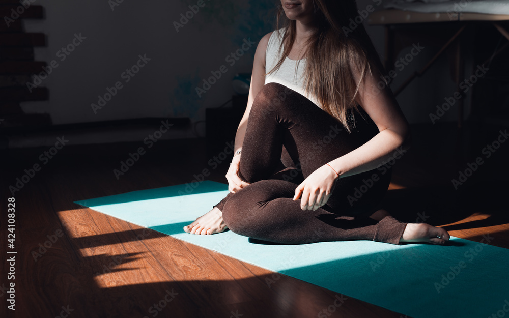 Woman practicing meditation in the studio, sitting in lotus position, doing stretching. Yoga concept, healthy lifestyle, stretching Woman practicing meditation in the studio, sitting in lotus position, doing stretching. Yoga concept, healthy lifestyle, stretching