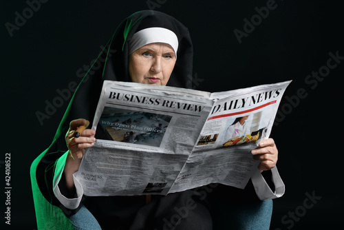 Senior nun with newspaper a...