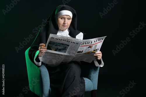 Senior nun with newspaper a...