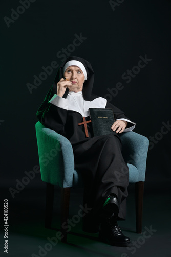 Senior nun with cigar and B...