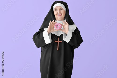 Senior nun with donut on co...