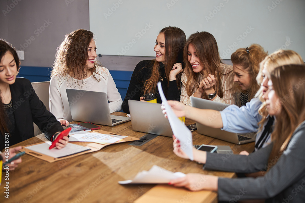 © Svitlana - Creative team sitting at the table and discussing business project © Svitlana - Creative team sitting at the table and discussing business project