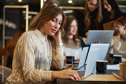 Charming woman working on project with colleagues in office