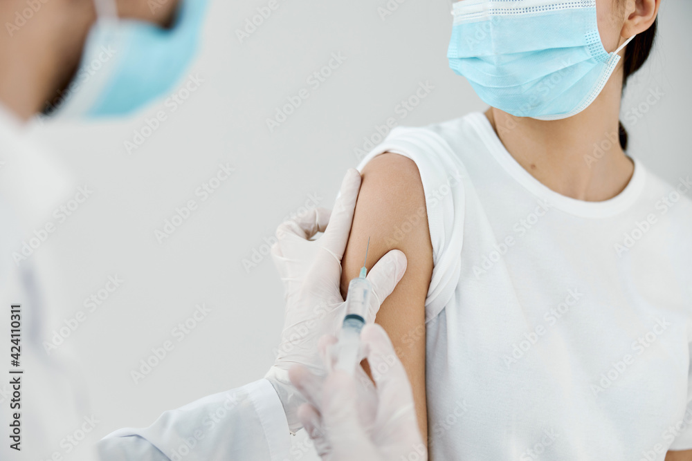 doctor giving injection to woman's shoulder close-up vaccination laboratory infection doctor giving injection to woman's shoulder close-up vaccination laboratory infection