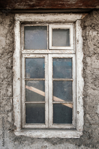 House facade with dirty white damaged window