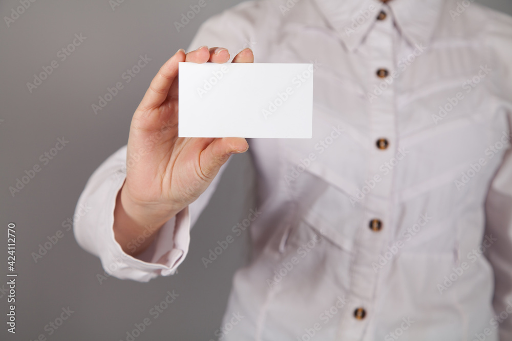 Woman holding blank business card. Gray background. Woman holding blank business card. Gray background.
