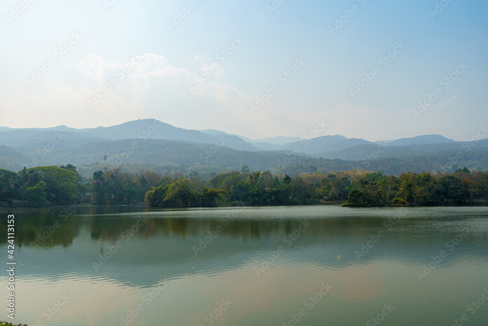 landscape lake views at Ang Kaew Chiang Mai University in the pollution fog in nature forest Mountain dust air pollution at 2.5 or Small particle PM 2.5 microns background with white cloud in Thailand