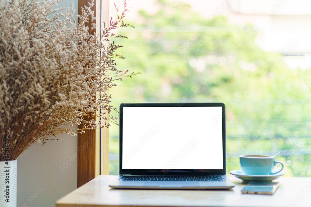 Mockup of laptop computer with empty screen with coffee cup and smartphone on table of the coffee shop background,White screen Mockup of laptop computer with empty screen with coffee cup and smartphone on table of the coffee shop background,White screen