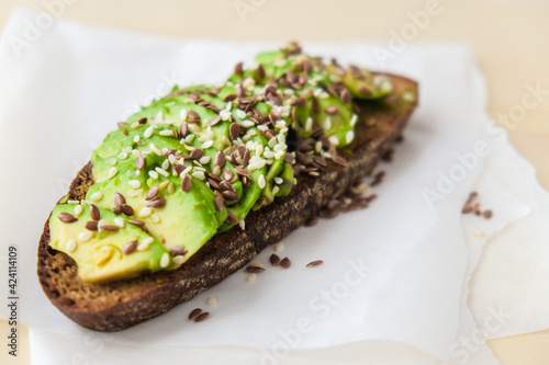 Healthy avocado toast on concrete background. Wholegrain bread, sesame flax seeds. Vegan keto diet. Healthy eating. Trendy guacamole sandwich photo