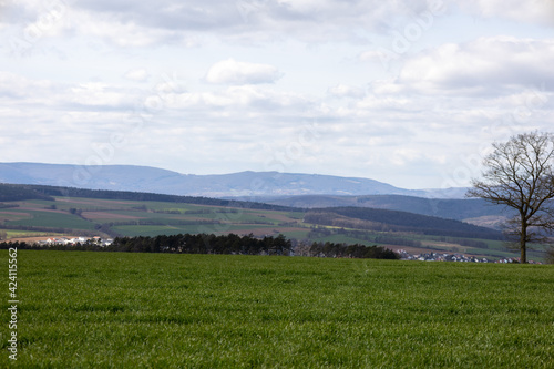 Ferner Blick über eine Landschaft mit Straßen und Windrädern am Horizont