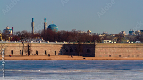 The walls of the Peter and Paul Fortress. The Saint Petersburg Mosque in the distance. Neva river, spring sunny day.