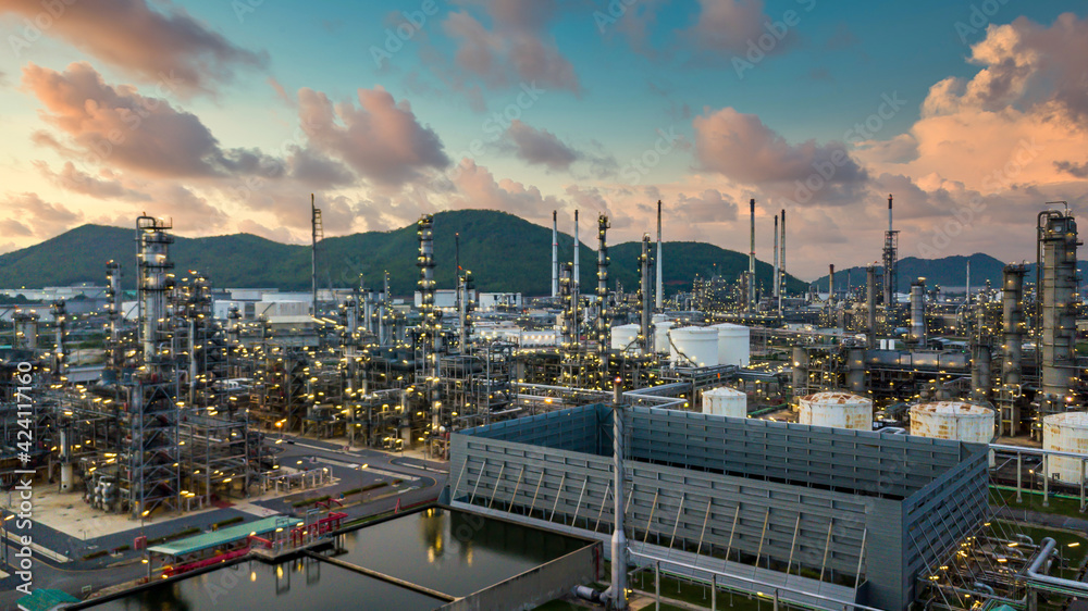 Oil refinery plant from industry zone, Aerial view oil and gas petrochemical industrial, Refinery factory oil storage tank and pipeline steel at twilight.
