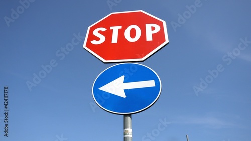 Stop sign on the road in a blue sky - only one direction possible