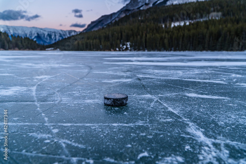 Photography Hockey Puck on frozen lake in Mountains