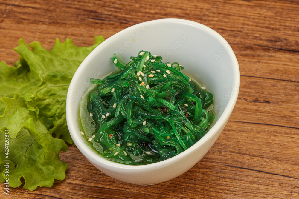 Green Chuka Seaweed Salad Isolated on White Background Top View. Wakame Sea Kelp Salat Green Chuka Seaweed Salad Isolated on White Background Top View. Wakame Sea Kelp Salat