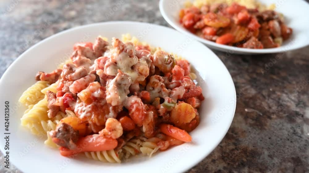 Pasta with vegetables, meet and cheese on wooden table Pasta with vegetables, meet and cheese on wooden table