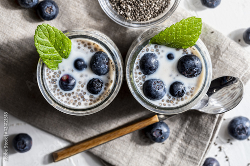 Appetizing, healthy and refreshing chia seed pudding with fresh blueberries and mint leaves. Vegetarian and vegan food with healthy superfoods. Homemade look.Top view.