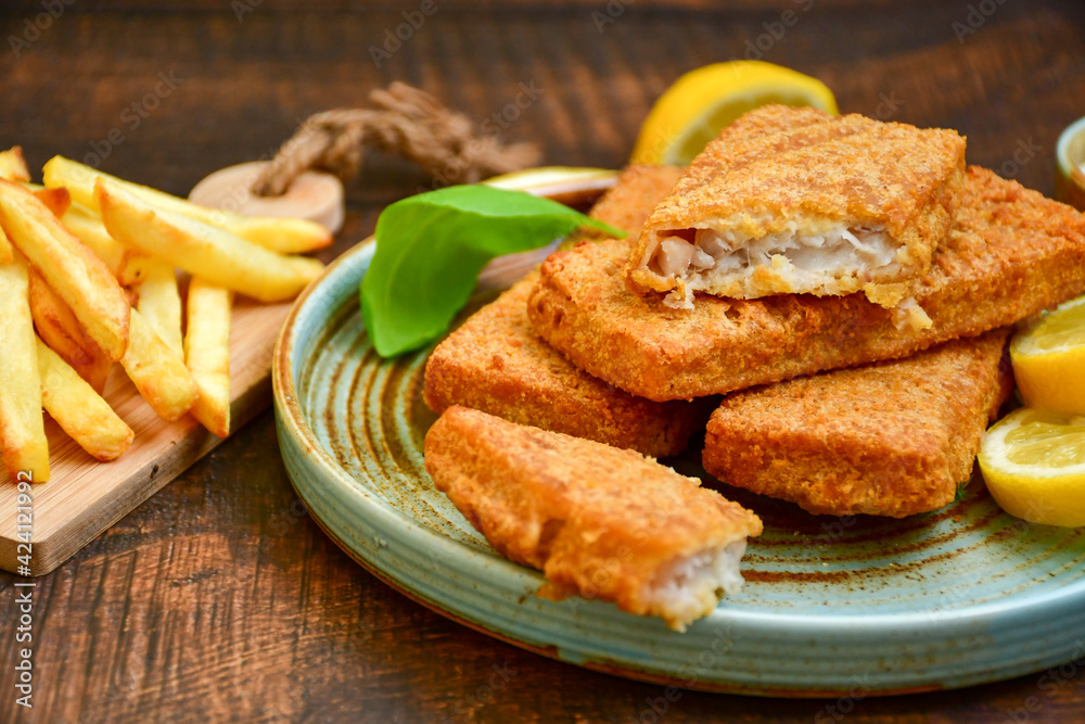 Close up of crispy breaded deep fried alaska pollock fillets with breadcrumbs served with remoulade sauce french fries and fresh lemon Close up of crispy breaded deep fried alaska pollock fillets with breadcrumbs served with remoulade sauce french fries and fresh lemon
