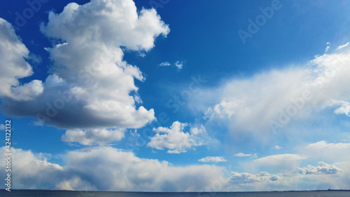 Bluy sky with clouds above the blue lake or river