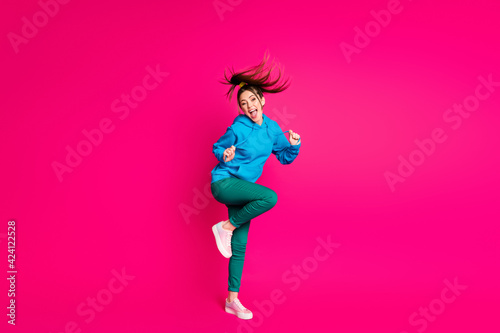 Full length photo of sweet funny young lady wear blue sweater dancing standing one leg isolated bright pink color background