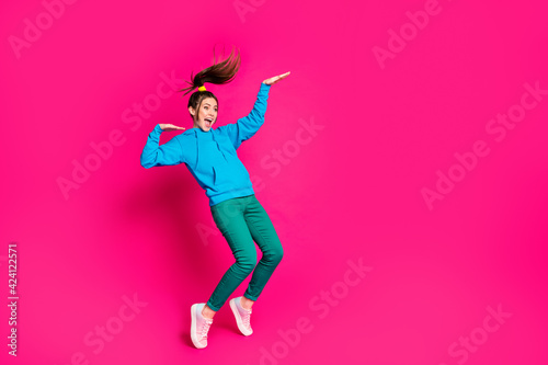 Full size photo of young crazy smiling cheerful girl look copyspace dancing having fun isolated on pink color background